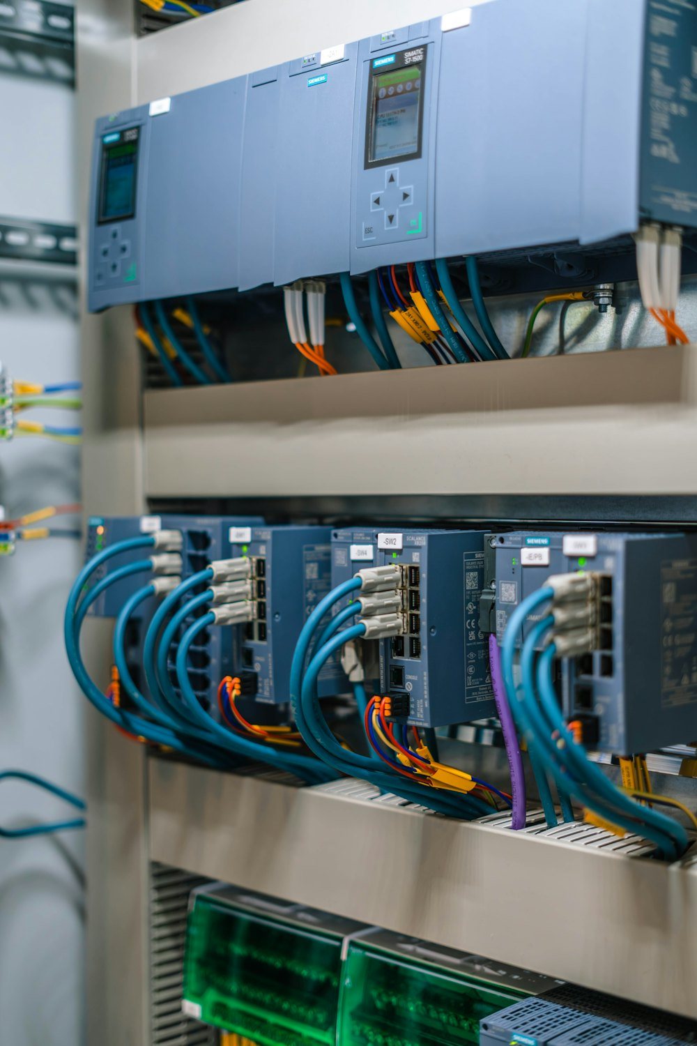 Close-up of Siemens S7-1500 PLCs and network switches wired with Profinet cables